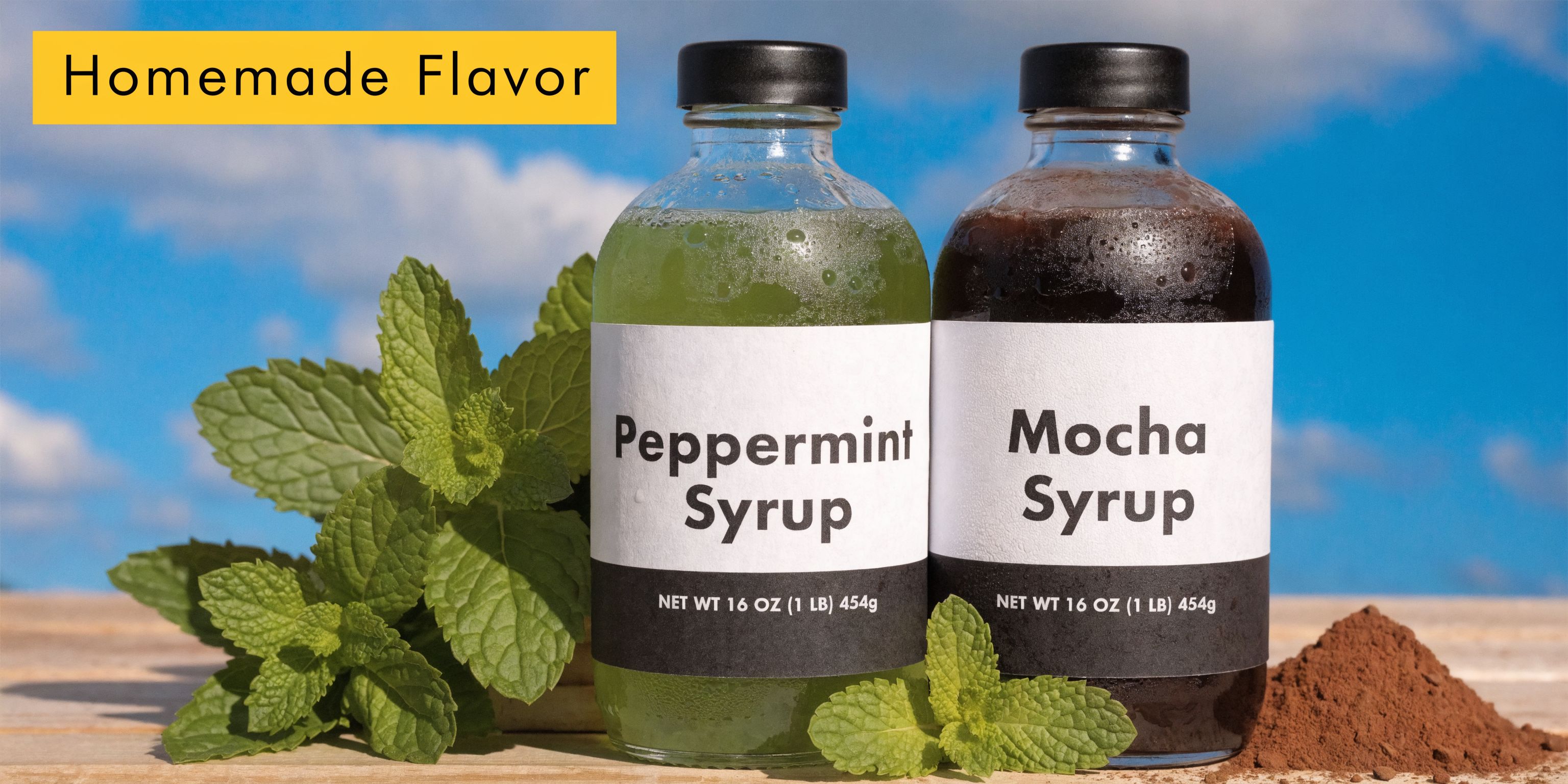 Two clear glass bottles of homemade Peppermint and Mocha syrup displayed with fresh mint leaves and cocoa powder.